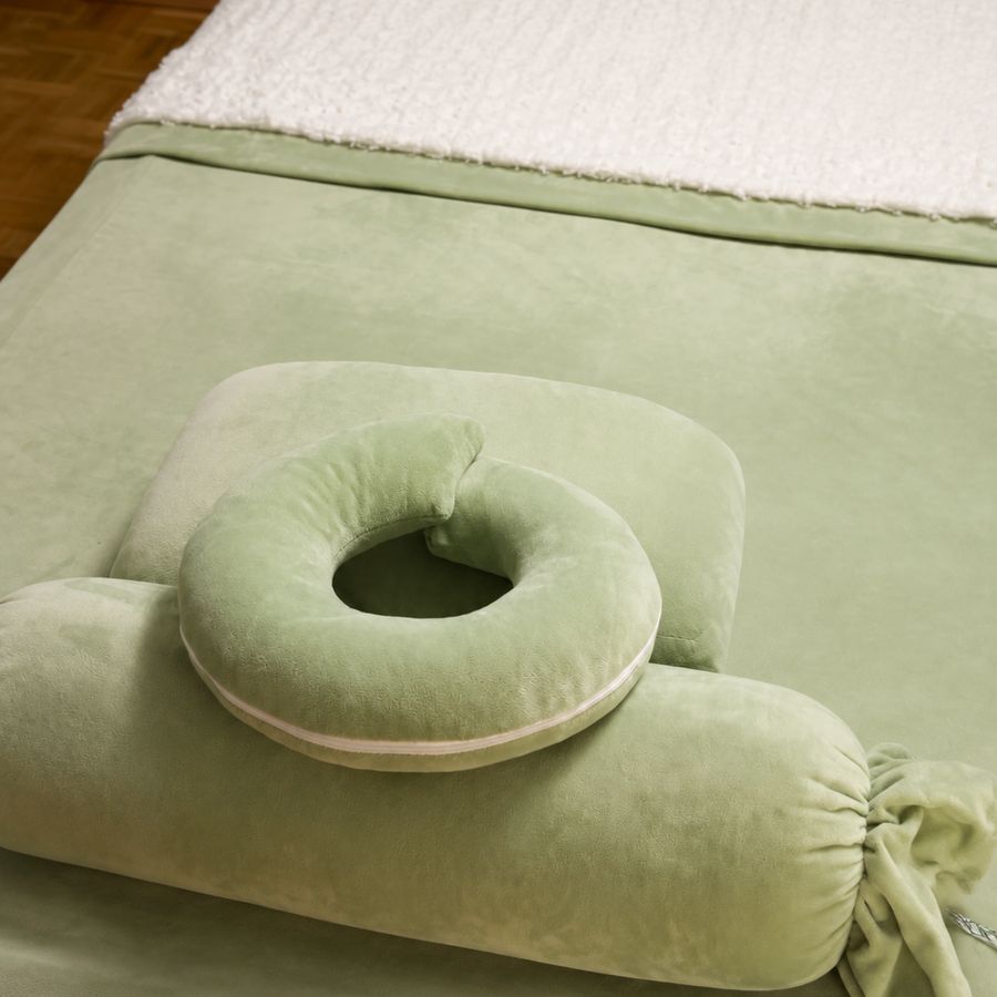 Massageliege mit frischem Bezug, Gesichtskissen und Nackenrolle