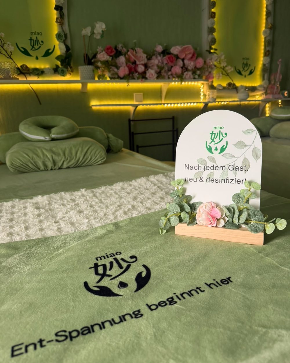 Frisch bezogene Liege mit dem Hinweisschild „Nach jedem Gast: neu und desinfiziert“
